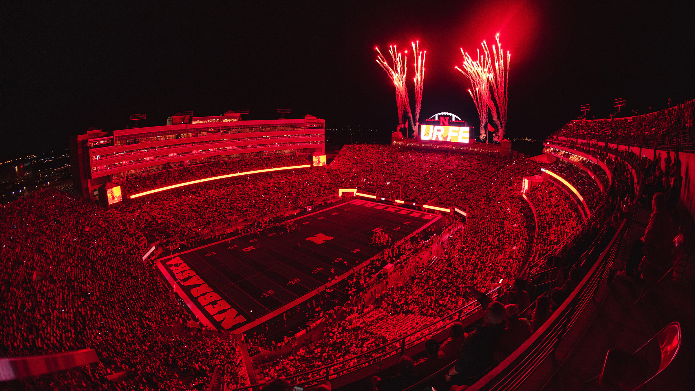 Memorial Stadium lit up with fireworks at night