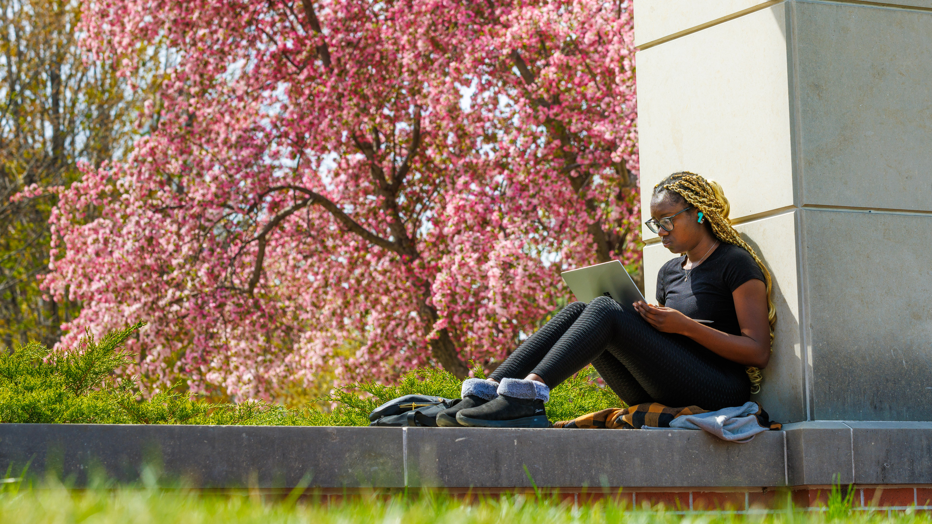 Student sitting outside using a laptop comuter