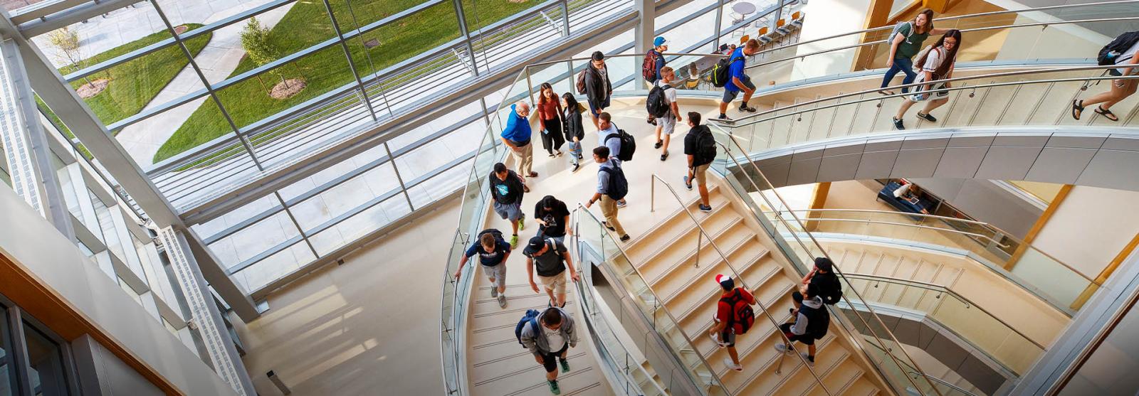 downward view of a staircase with students walking up and down